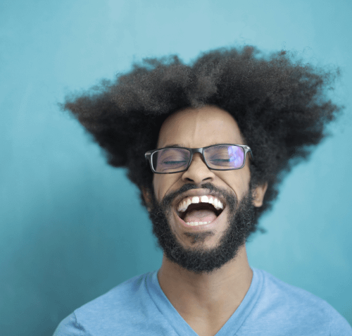 Lachender Mann mit Brille vor blauem Hintergrund