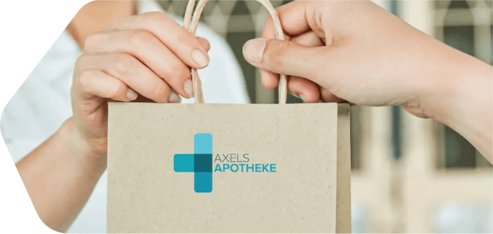 Eine Apothekentüte von Axels Apotheke wird übergeben